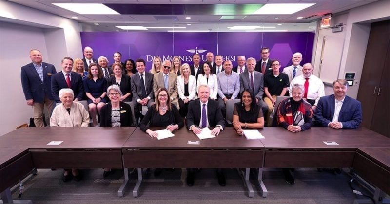 DMU Board Chair Michael Witte and University President Angela Walker Franklin - seated, fourth and third from right, respectively - are joined by DMU trustees, members of the McKinney family and West Des Moines leaders for the signing of the purchase of property for a new campus.