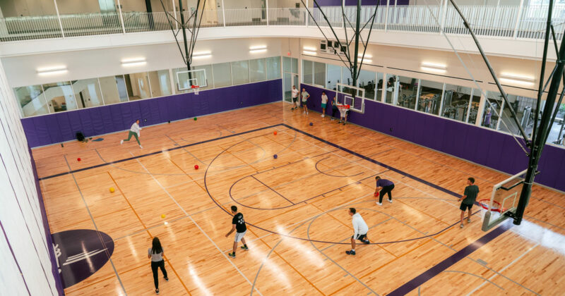 Students playing dodgeball in the Swift Gymnasium at DMU’s 8025 Grand Wellness Center