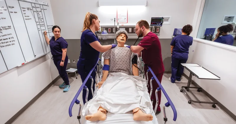 DMU students practice clinical procedures on a manikin in the Simulation Center.