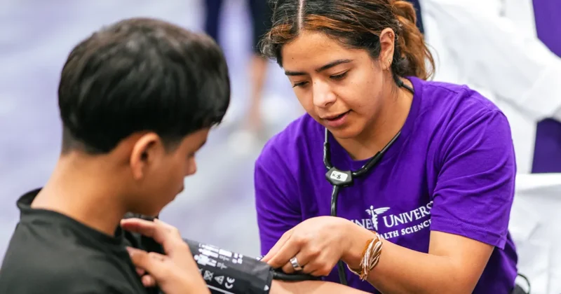A DMU student works with a patient at a clinical volunteer event.