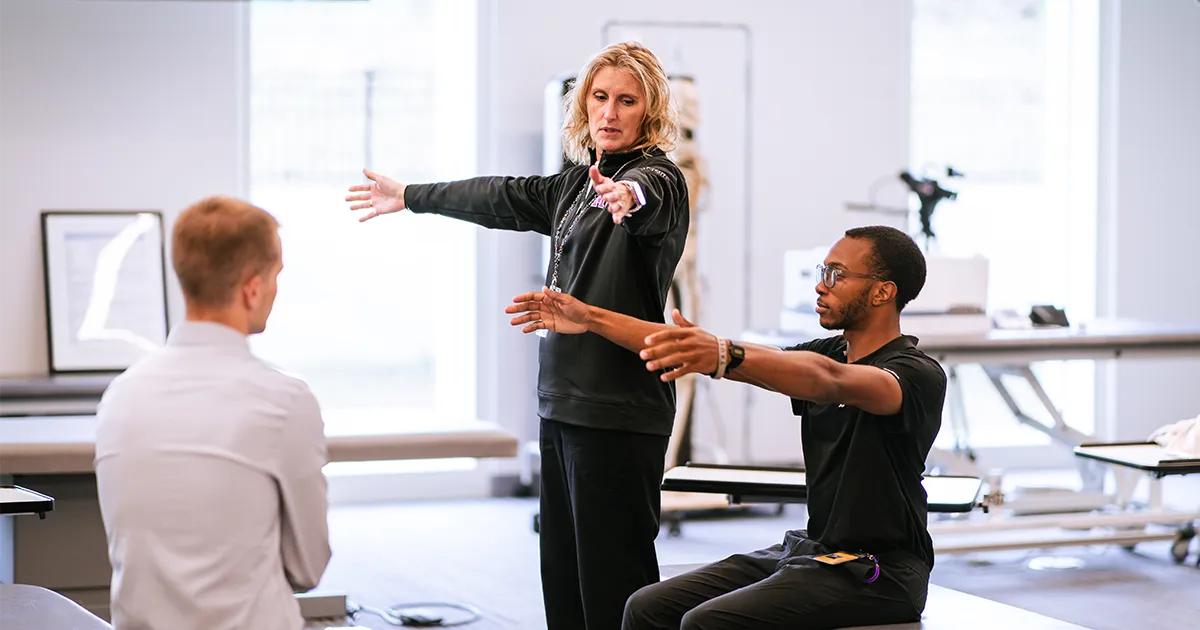 Health PASS participants work with DMU faculty on physical therapy exercises.