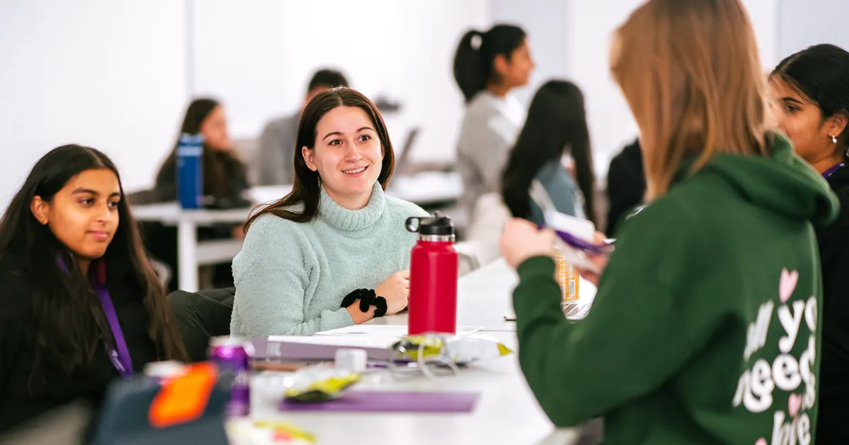 A DMU student speaks with attendees of the annual Mini Med School event during a group exercise.