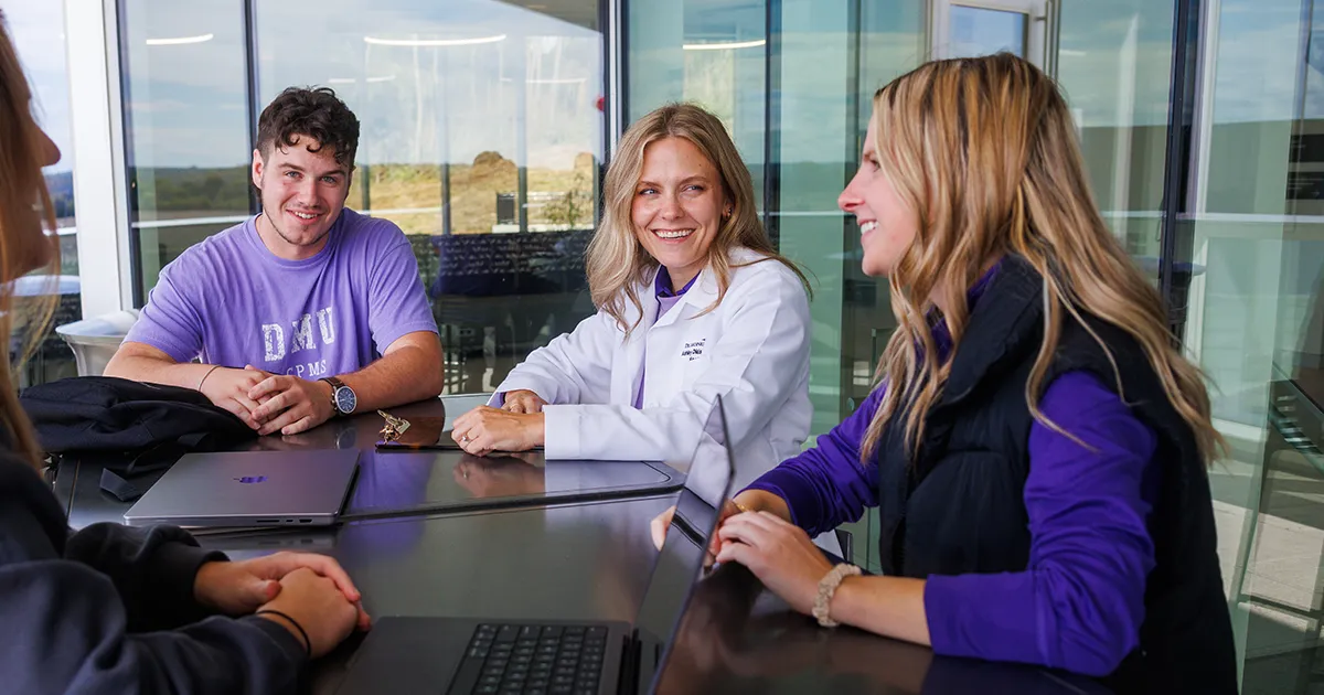 DPM faculty member engaging with students during a small-group discussion.