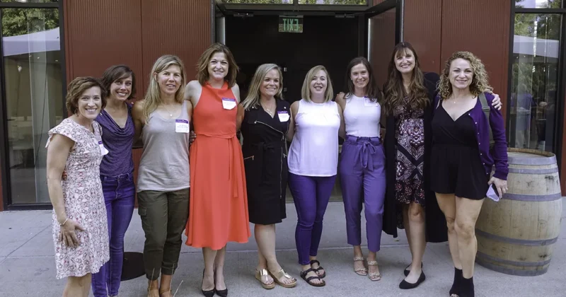 Several DMU alumni pose for a photo at a reunion event.
