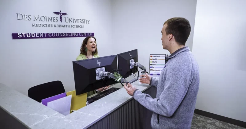 A DMU staff member and student interact in the reception area of the on-campus Student Counseling Center.