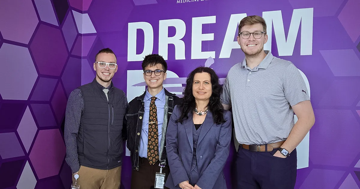 Elitsa Ananieva poses for a photo with DMU student researchers Tanner Wetzel, Anthony Deiehl and Max Swain.