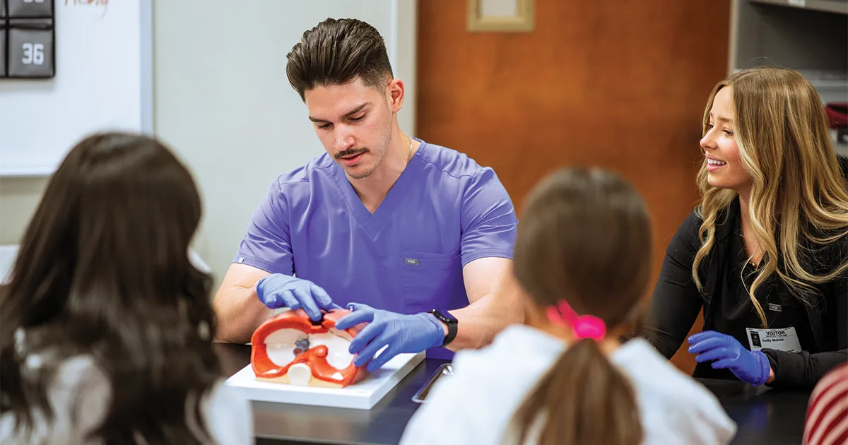 Juan Portal Figueroa, MSA’25, DO’29, and Emily Melvin, MSA’25, DO’29, demonstrate anatomy concepts using a model during an Anatomy Ambassadors Program visit to Ankeny Centennial High School.