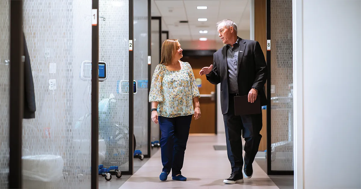 Kevin Kincaid, MHA’09, walks through a hospital hallway in conversation with a colleague.