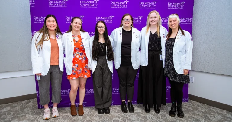 Group of six DMU students pose for a photo in front of a purple Des Moines University Medicine and Health Sciences backdrop during the annual Leadership and Service Awards ceremony.