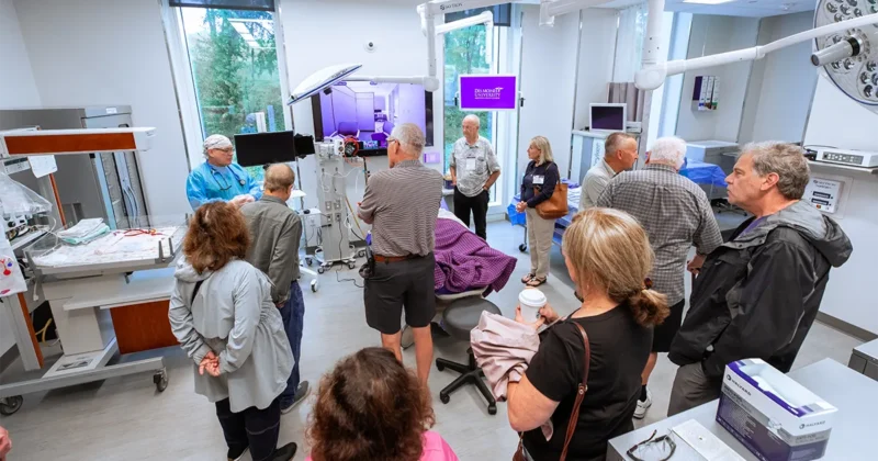DMU alumni participate in a campus tour in the simulation center during the 2026 alumni reunion.