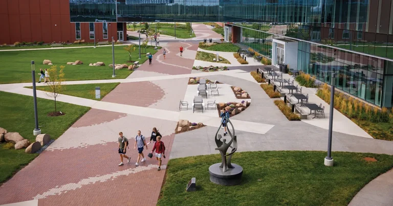 Aerial view of The Plaza at Des Moines University Medicine and Health Sciences, with students walking between campus buildings, outdoor seating areas and the bronze sculpture "The Gathering."